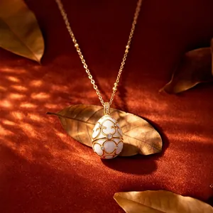 Elegante collar con colgante de huevo en esmalte blanco, filigrana de oro y circonitas