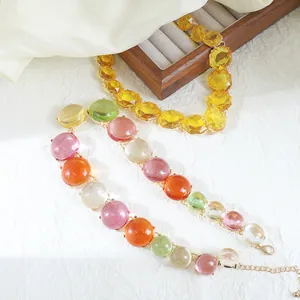 Close-up view of a colorful jelly bead necklace and a yellow geometric gem necklace