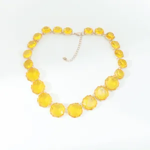 Detailed close-up of a Bohemian yellow geometric jelly stone necklace on white background.