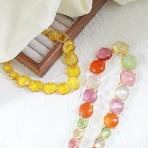 Close-up detail of Bohemian style colorful jelly resin necklace and yellow faceted choker