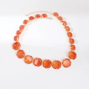 Close-up of bohemian style necklace featuring vibrant orange faceted jelly stones