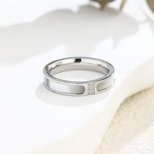 Dettaglio macro di un anello d'argento con intarsi in conchiglia e tre piccoli cristalli.