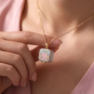 Close-up detail of the light blue enamel heart square locket with 'MOM' engraved text.
