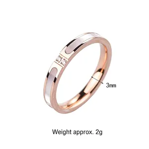 Primer plano de anillo en oro rosa de 3 mm con nácar blanco y dos pequeños diamantes.