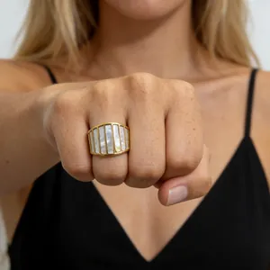 Close-up van een goudkleurige roestvrijstalen ring in Franse stijl met parelmoer.