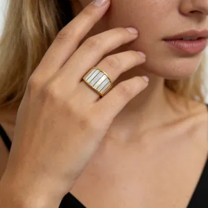 Detailopname van een minimalistische ring van titaniumstaal met wit parelmoer inleg