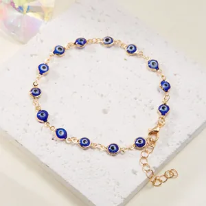 Gold-tone chain bracelet featuring blue Evil Eye beads with adjustable lobster clasp.