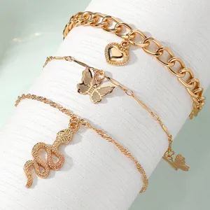 Elegant gold-tone charm bracelet set featuring butterfly, snake, and heart pendants