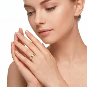 Elegant 14K gold plated stainless steel band ring on female model hand detail view