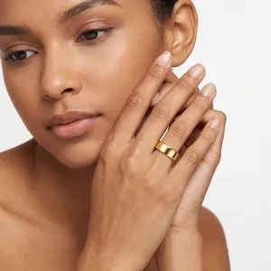 Close-up of a minimalist 14K gold plated stainless steel band ring on model's finger