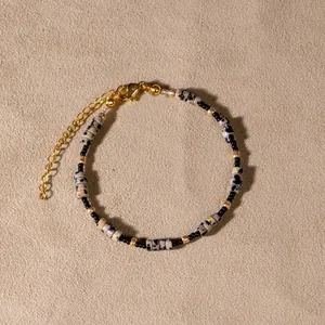Detail of handmade beaded bracelet with dalmatian jasper beads and gold-tone clasp.