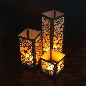 Vue détaillée de trois lanternes en papier hibiscus découpées au laser, lumière chaude