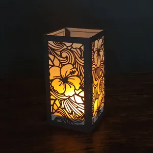 Vue détaillée de la lanterne en papier hibiscus découpée au laser sur une table en bois sombre.