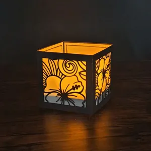 Vue détaillée d'un abat-jour en papier découpé au laser hibiscus avec lueur ambrée chaude