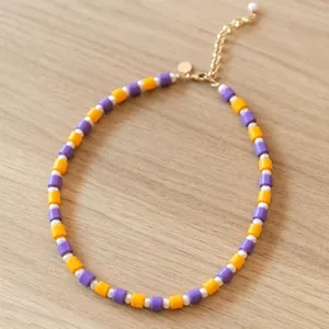 Detaillierte Makroansicht einer Vintage-Perlenkette mit lila und gelben runden Perlen