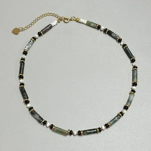 Makrodetail der französischen Retro-Perlenkette mit grünen Steinen und Goldakzenten
