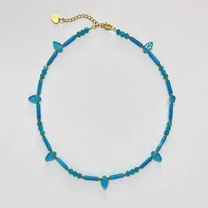 Detailaufnahme einer blauen Vintage-Türkis-Halskette mit goldenem Herzanhänger im Design
