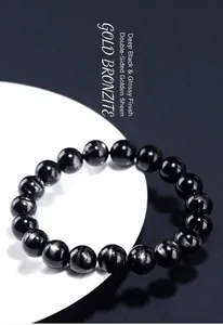 Close-up of natural golden hypersthene bracelet beads with golden eye effect