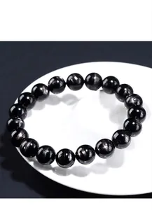 Macro detail showing natural hypersthene black beaded bracelet with metallic luster