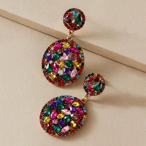 Close-up detail of luxurious gold-tone geometric earrings with colorful rhinestones