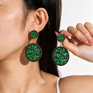 Emerald green rhinestone geometric drop earrings worn by a model for a luxury look