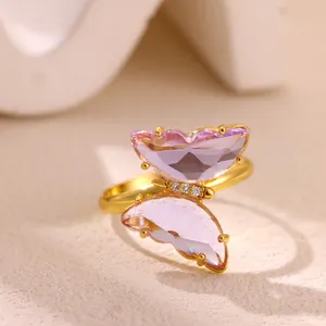 Vista macro de un anillo de mariposa chapado en oro con piedras púrpuras y circonitas