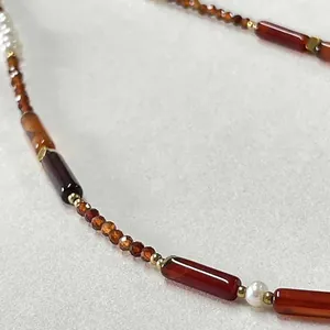 Macro view of vintage beaded necklace with natural red stones and elegant pearls
