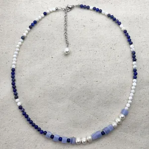 Detail view of vintage natural stone and pearl beaded necklace with extender chain.
