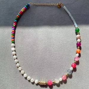 Detailed view of handmade beaded necklace with natural stones, pearls and gold heart charm