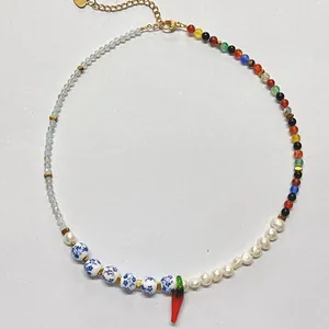 Detailed view of vintage mixed beaded necklace with pearls and red chili pendant.