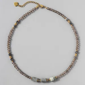 Macro view of natural stone beaded necklace with gray faceted beads and gold accents
