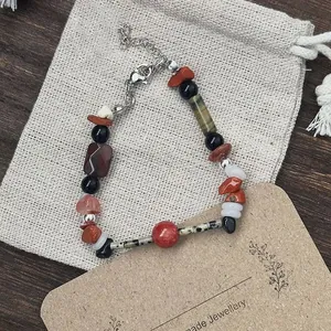 Detailed view of handmade necklace with mixed natural stones and linen packaging