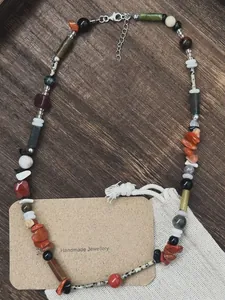 Detail of handmade vintage natural stone beaded necklace on wooden background.
