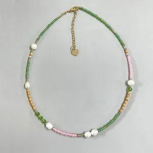 Detailed view of handmade beaded necklace with colorful seed beads and freshwater pearls.