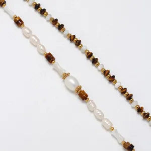 Vista macro dettagliata del bracciale vintage francese con occhio di tigre e perle