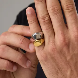 Primer plano de anillos de sello minimalistas de acero inoxidable en oro y plata mate.