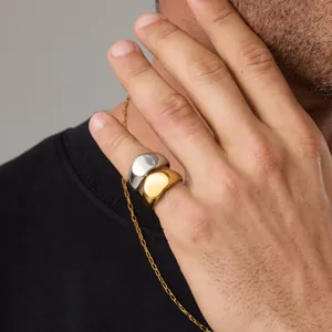 Primer plano de anillos de cúpula minimalistas de acero inoxidable en acabados oro y plata