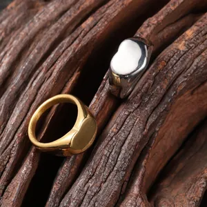Vista detallada de anillos de sello minimalistas con forma de corazón en acero oro y plata