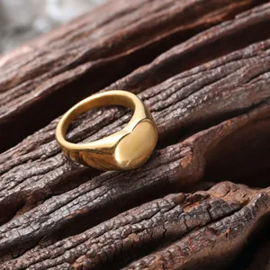 Vista detallada de un anillo minimalista de acero inoxidable dorado con superficie lisa de corazón