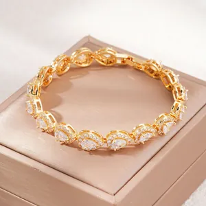 Dettaglio di un bracciale in zircone dorato a goccia su una scatola regalo elegante