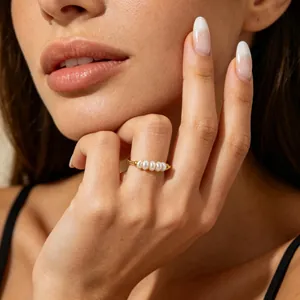 Close-up of a French style titanium steel ring featuring five baroque pearls on a model