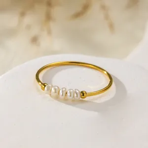 Detailed macro shot of an elegant gold titanium steel ring with five baroque pearls