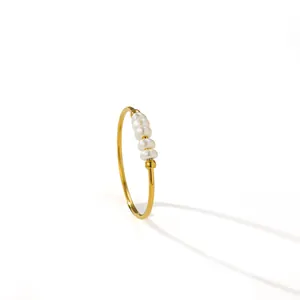 Detailed macro shot of a gold titanium steel ring with four delicate white pearls