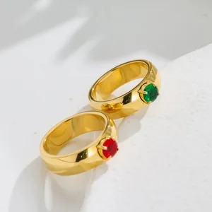 Close-up of titanium steel rings with shiny red and green zircon gemstones