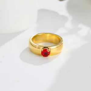 Detail of an elegant gold titanium steel ring featuring a vibrant red zircon solitaire