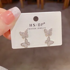 Sparkling silver butterfly drop earrings with pavé crystals on a jewelry display card