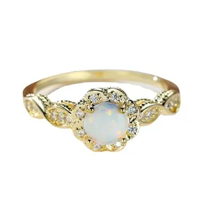 Vintage gold-plated floral ring featuring a central white opal and clear stones.