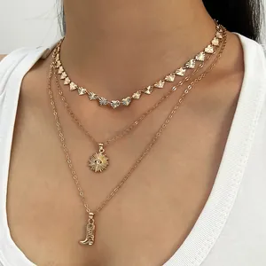 Detailopname van gouden gelaagde ketting met cowboylaars en zon hanger hangers