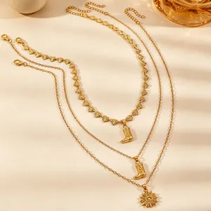 Detailweergave van een gelaagde gouden vintage ketting met cowboylaars bedeltjes