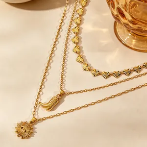 Detail van vintage goudkleurige meerlagige ketting met cowboylaars hanger.